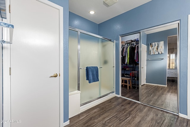 bathroom featuring wood-type flooring and an enclosed shower