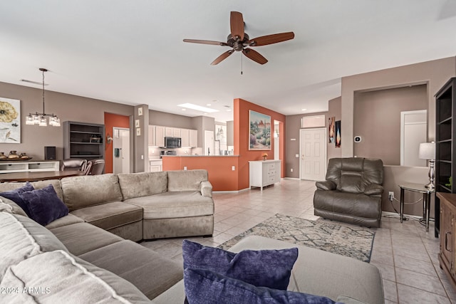 living room featuring light tile patterned floors and ceiling fan with notable chandelier