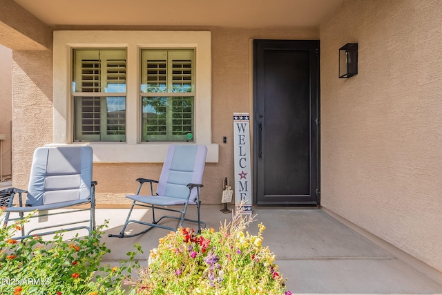 12238 W Patrick Ct, Sun City, AZ 85373 - view of exterior entry with stucco siding and covered porch