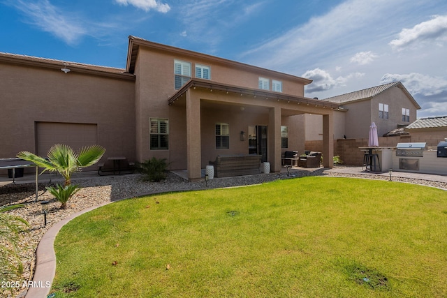 12238 W Patrick Ct, Sun City, AZ 85373 - rear view of house with stucco siding, area for grilling, an attached garage, and a patio area