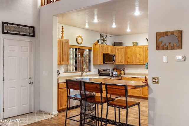 6523 Wild Cat Way, Pinetop, AZ 85935 - kitchen with stainless steel appliances, light wood-type flooring, a sink, light countertops, and baseboards