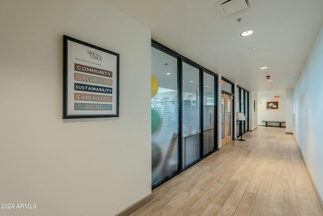 corridor featuring expansive windows and light hardwood / wood-style flooring