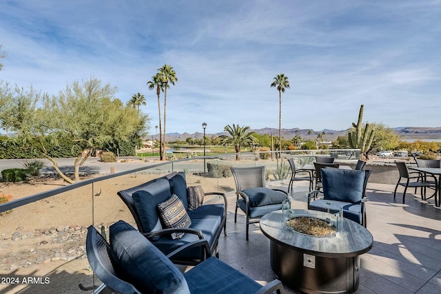 view of patio / terrace featuring a mountain view and an outdoor living space with a fire pit