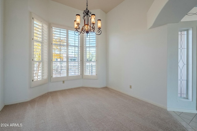 carpeted empty room with a chandelier