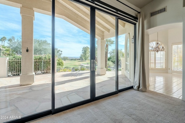 entryway with carpet flooring, vaulted ceiling, and a notable chandelier