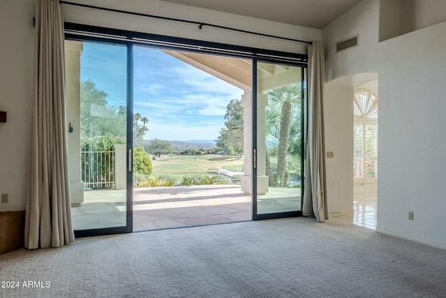 doorway with light colored carpet and plenty of natural light