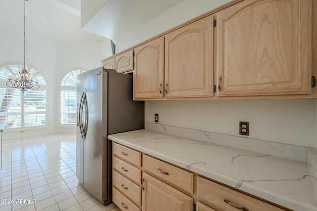 kitchen featuring light brown cabinets, light tile patterned floors, hanging light fixtures, and a notable chandelier