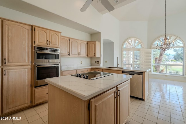 kitchen featuring appliances with stainless steel finishes, a center island, light tile patterned floors, and sink