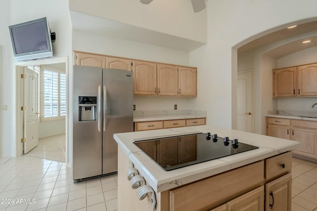 kitchen with light brown cabinets, black electric cooktop, stainless steel refrigerator with ice dispenser, and light tile patterned floors