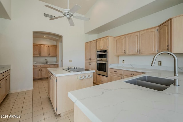 kitchen featuring double oven, sink, light tile patterned floors, high vaulted ceiling, and a center island