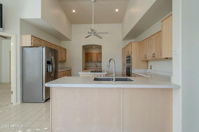 kitchen with kitchen peninsula, sink, high vaulted ceiling, and appliances with stainless steel finishes