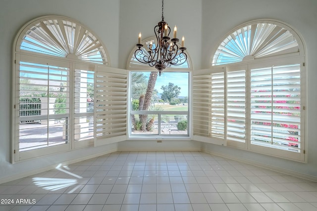 unfurnished dining area featuring light tile patterned floors, a healthy amount of sunlight, and a notable chandelier