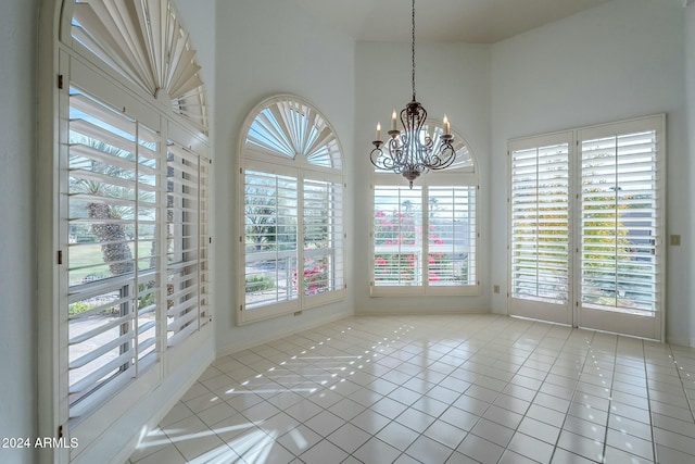 unfurnished dining area featuring plenty of natural light, light tile patterned floors, and an inviting chandelier