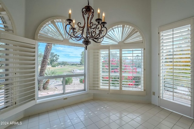 unfurnished dining area with light tile patterned floors and an inviting chandelier