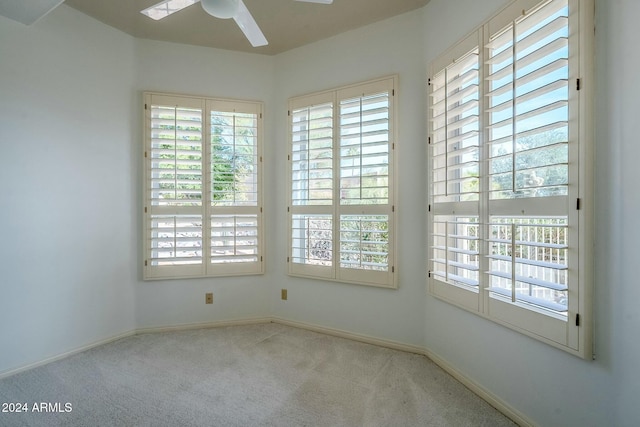 unfurnished room featuring light colored carpet and ceiling fan