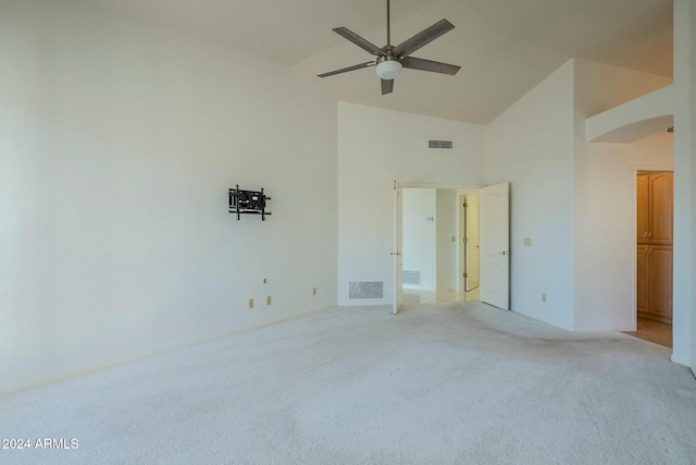 carpeted empty room featuring high vaulted ceiling and ceiling fan