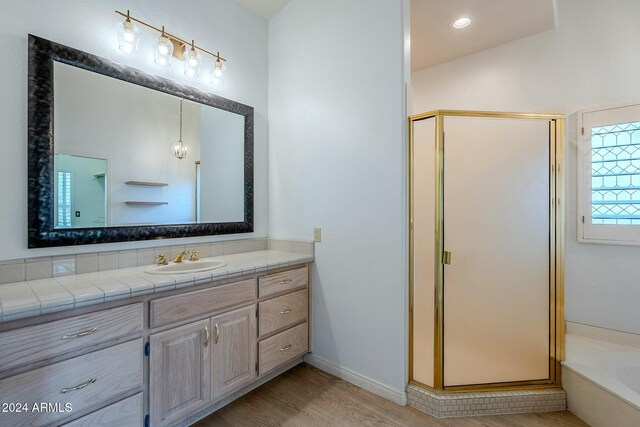 bathroom with hardwood / wood-style flooring, vanity, and walk in shower