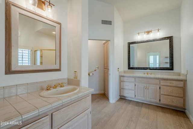 bathroom featuring walk in shower, vanity, and hardwood / wood-style flooring