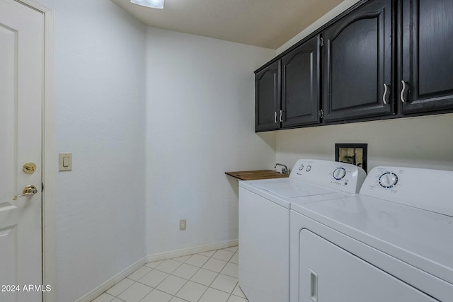 laundry room with washer and clothes dryer, light tile patterned flooring, and cabinets