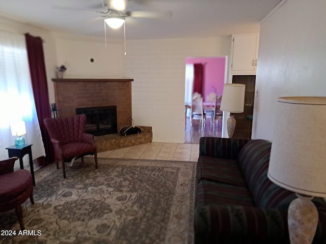 living area featuring a ceiling fan, a brick fireplace, and tile patterned flooring