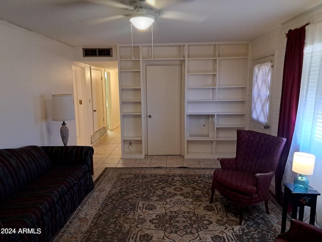 living area featuring a ceiling fan, built in features, light tile patterned flooring, and visible vents