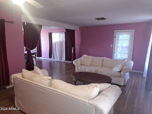 living room featuring ceiling fan, baseboards, wood finished floors, and visible vents