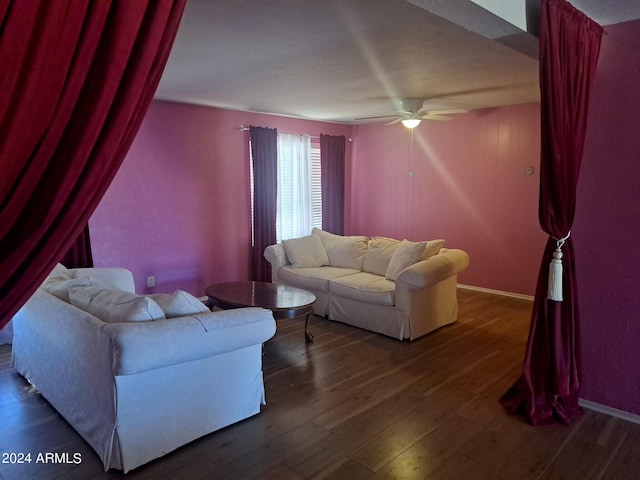 living room with a ceiling fan, baseboards, and dark wood-style flooring