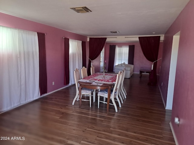 dining room with wood finished floors, visible vents, and baseboards