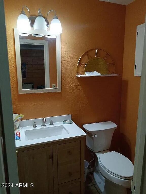 half bath featuring toilet and vanity