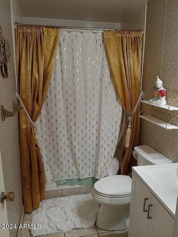 bathroom featuring curtained shower, toilet, vanity, and tile patterned floors