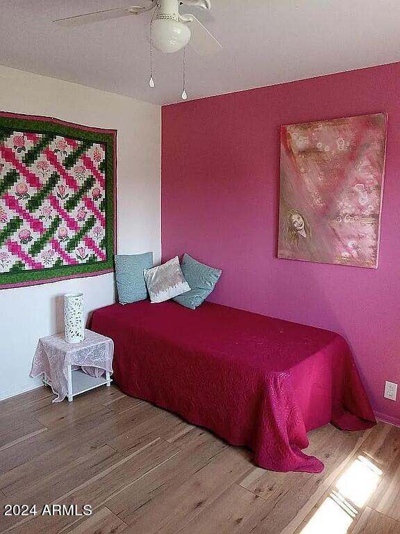 bedroom with a ceiling fan and wood finished floors