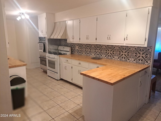 kitchen with white cabinets, light tile patterned floors, backsplash, white range with gas cooktop, and ventilation hood