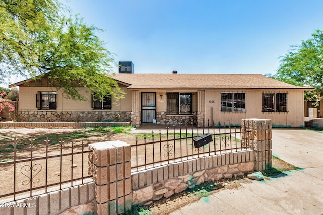 6426 W Mulberry Dr, Phoenix, AZ 85033 - ranch-style home with stone siding, a fenced front yard, and a shingled roof