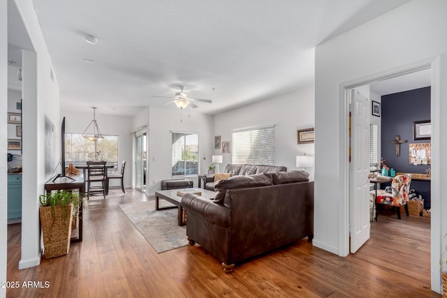 living room featuring ceiling fan, wood finished floors, and baseboards