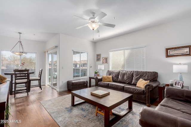 living room with baseboards, a ceiling fan, and wood finished floors