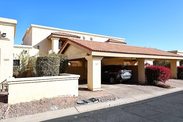 mediterranean / spanish-style house with covered parking, a tile roof, and stucco siding