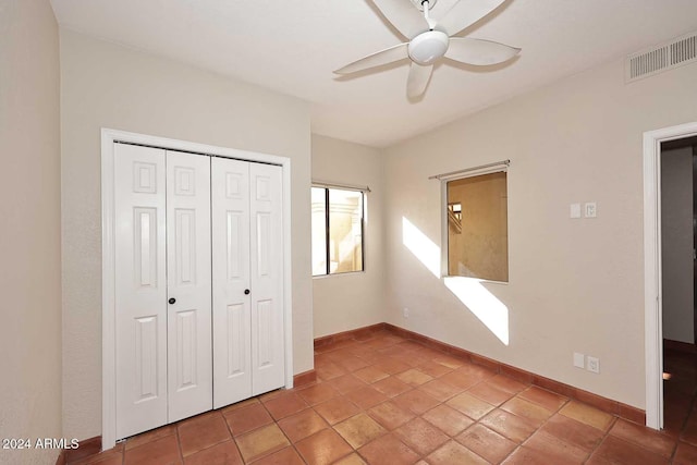 unfurnished bedroom with a ceiling fan, baseboards, visible vents, and a closet