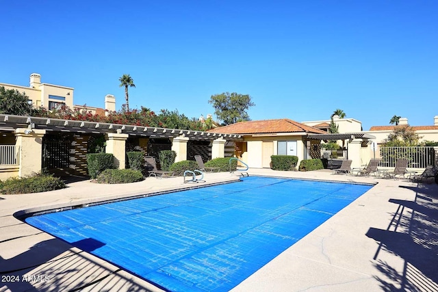 pool with a patio, fence, and a pergola