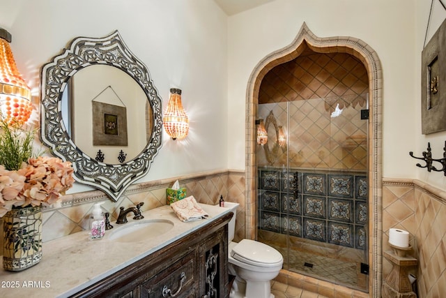 bathroom with toilet, vanity, tile walls, and walk in shower