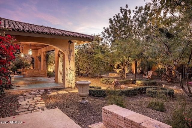 yard at dusk featuring a patio area