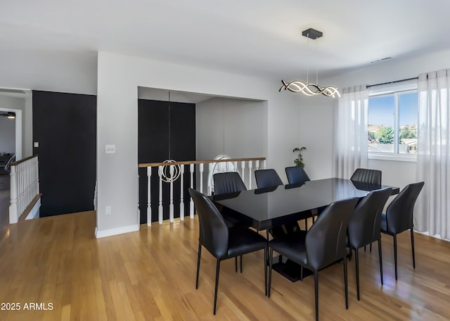 dining area with light wood-type flooring and baseboards