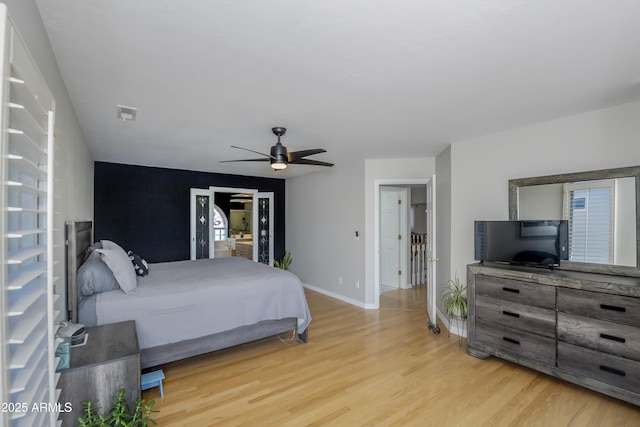 bedroom featuring baseboards, a ceiling fan, and light wood-style flooring