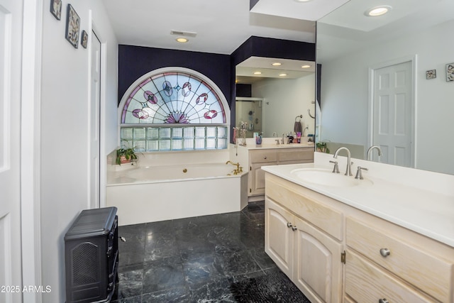 bathroom featuring a garden tub, visible vents, a shower stall, two vanities, and a sink