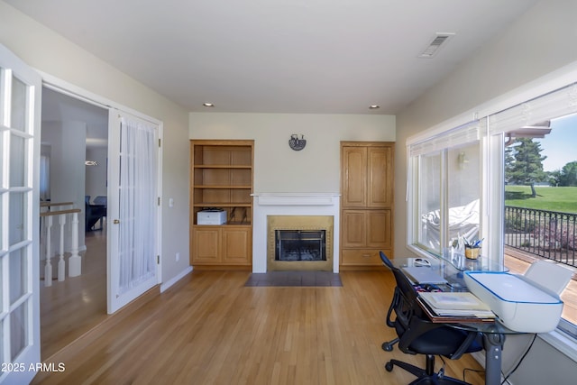 office with visible vents, a fireplace, light wood-type flooring, baseboards, and recessed lighting