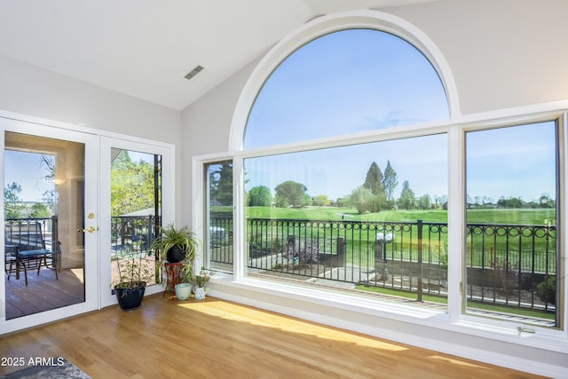 sunroom featuring golf course view and visible vents