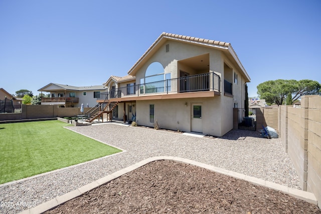back of property featuring a fenced backyard, stucco siding, a tile roof, and stairway