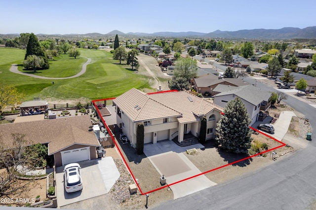 drone / aerial view with a residential view, a mountain view, and golf course view