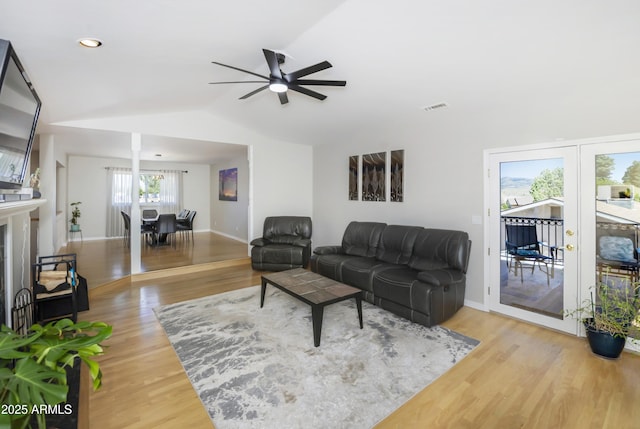 living room with ceiling fan, lofted ceiling, wood finished floors, and visible vents