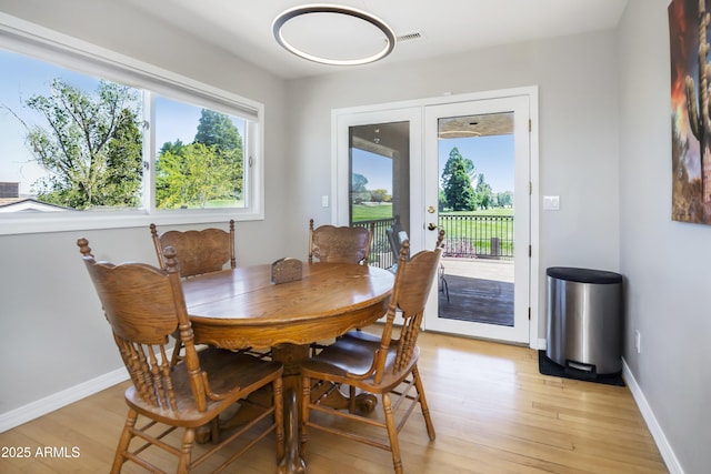 dining space with baseboards and light wood-style flooring