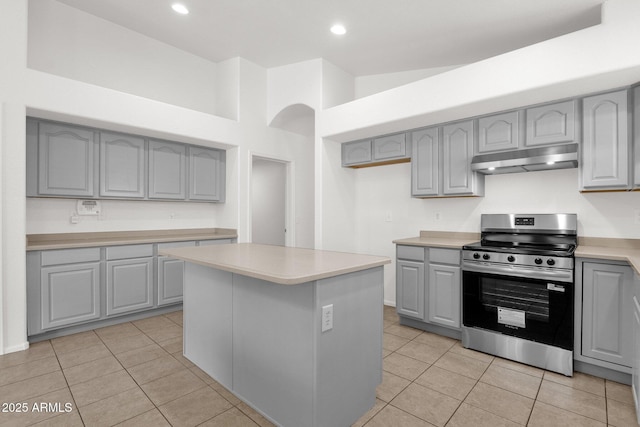kitchen featuring light countertops, gray cabinets, under cabinet range hood, and stainless steel range with electric cooktop